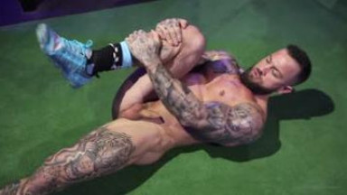 Nude bodybuilder streching in gym